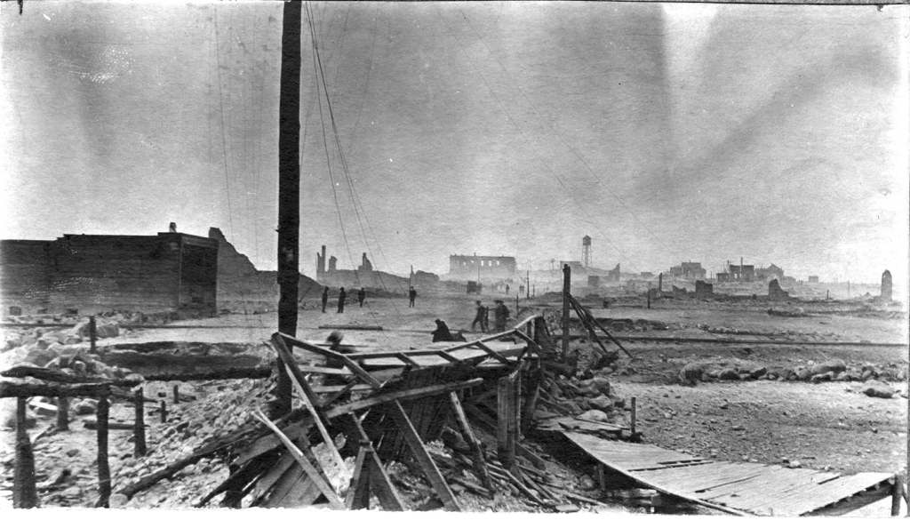 Black and white photo of the ruins of a town destroyed by fire. 