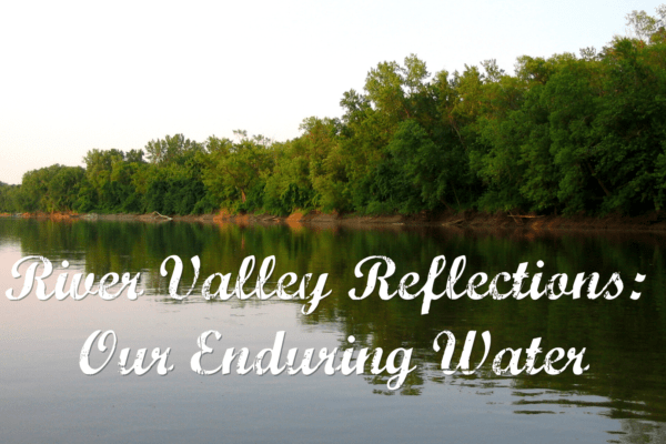 Color image of a river with green trees on a bluff with the words "River Valley Reflections: Our Enduring Water" written in cursive across the middle.