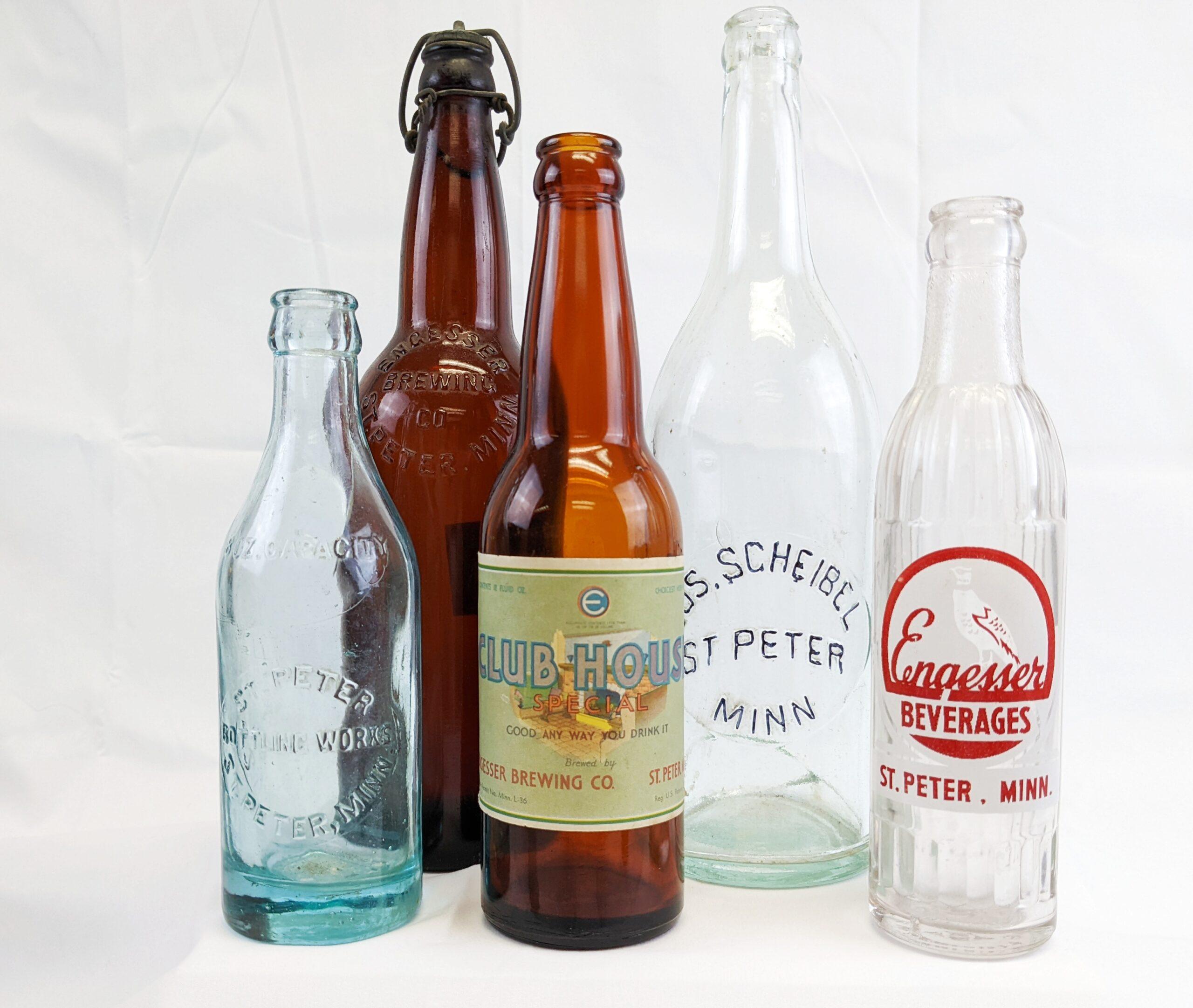 Various color and size glass bottles in front of a white background.