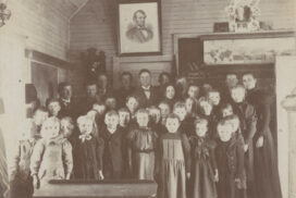 Teacher with students inside a rural schoolhouse.