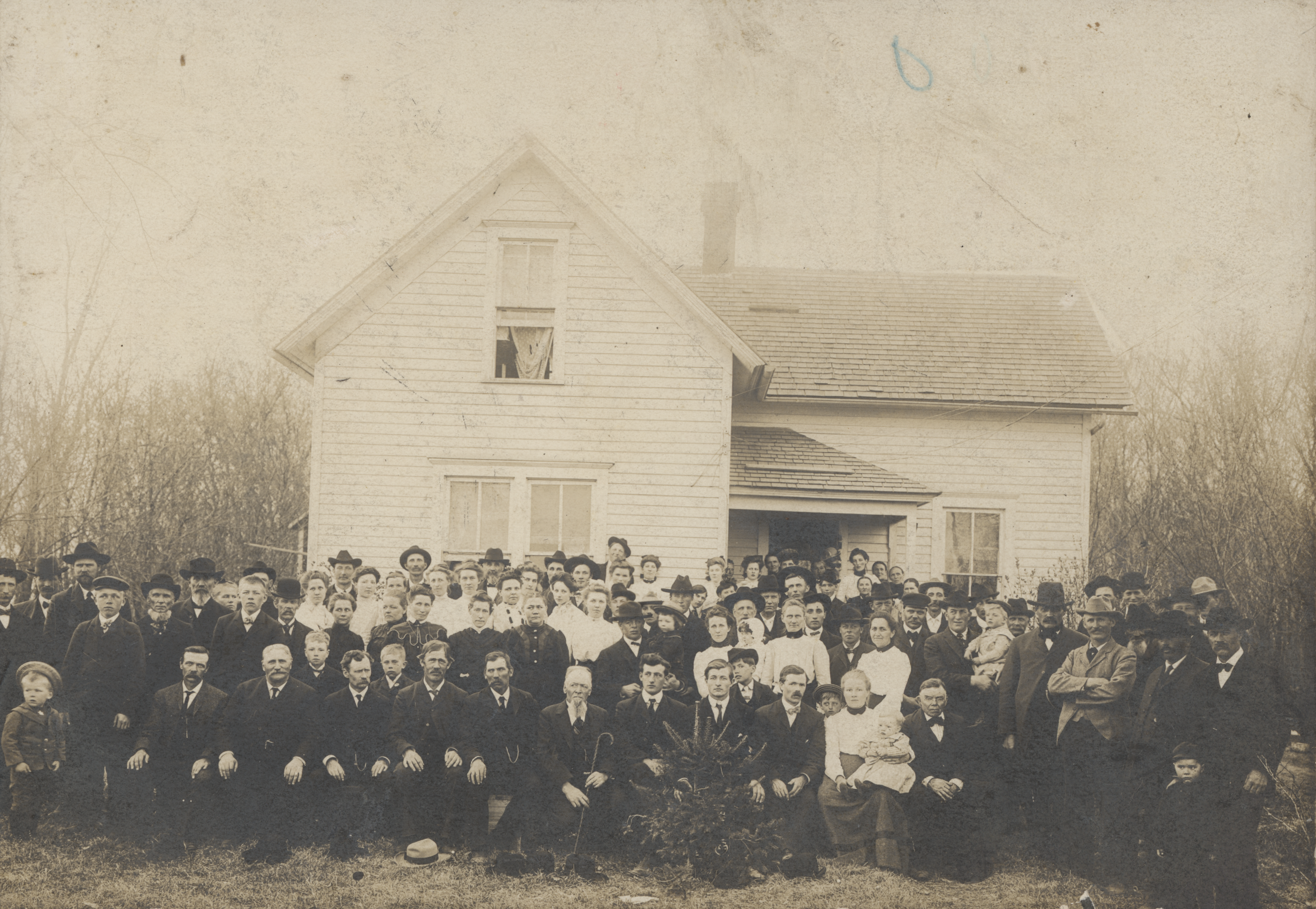 a group of people posing for a photo in front of a house
