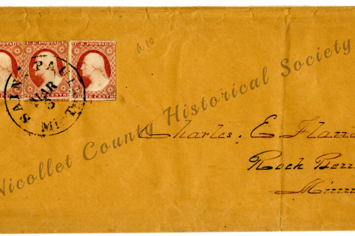 A vintage brown envelope with two red three-cent U.S. stamps and a black circular postal mark. The envelope is addressed to Charles E. Flandrau, Roch Peind, Minnesota, with “Nicollet County Historical Society” printed diagonally.