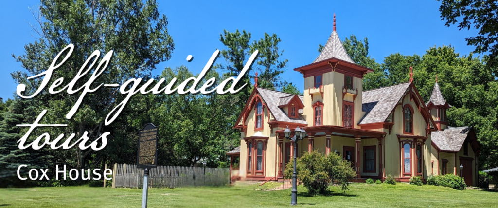 A historic Victorian-style house with a turret sits on a green lawn under a blue sky. Text reads: “Self-guided tours. Cox House.” A historical marker and lamp post are visible in front of the house.